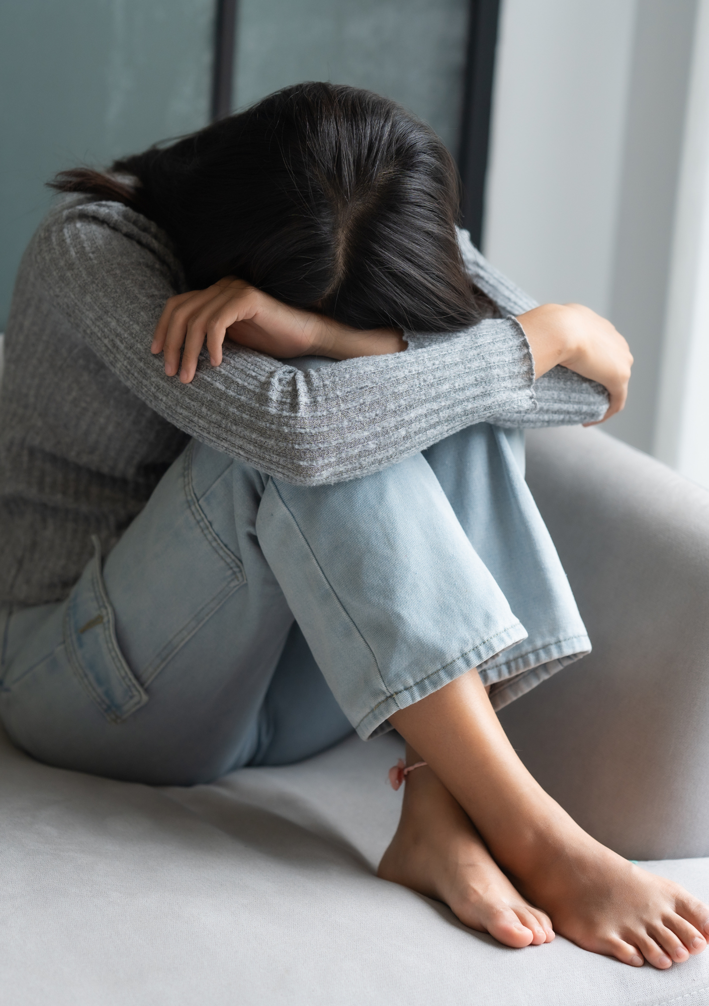 Woman with head in her arms sitting down