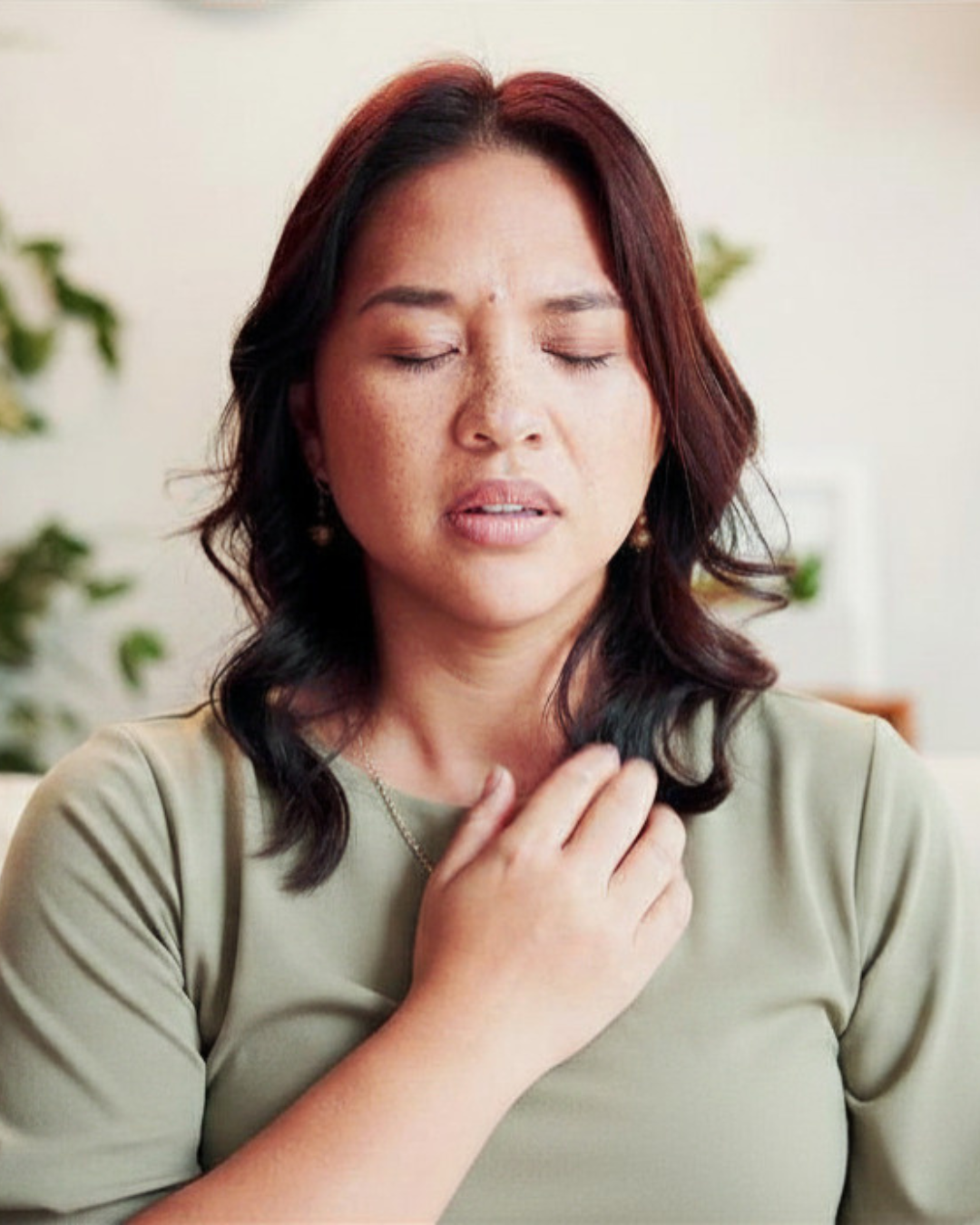 woman holding hand to chest