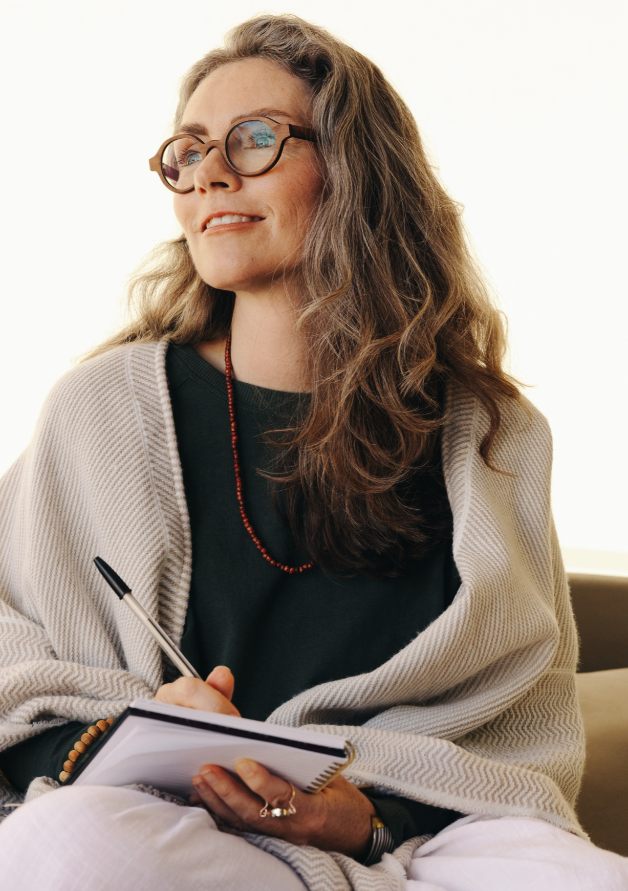 Woman sitting with a notepad and pen