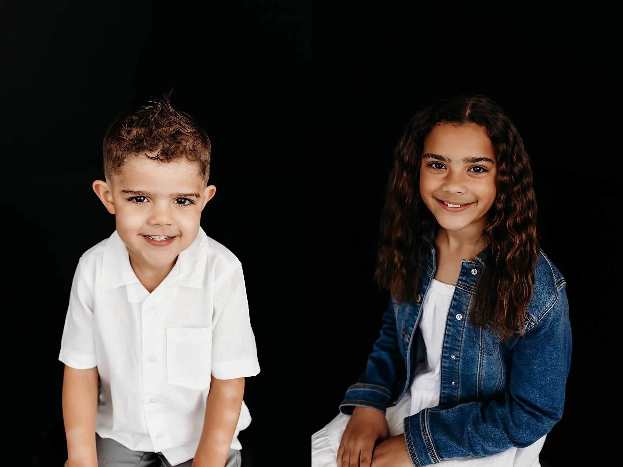two children smiling in front a black backdrop