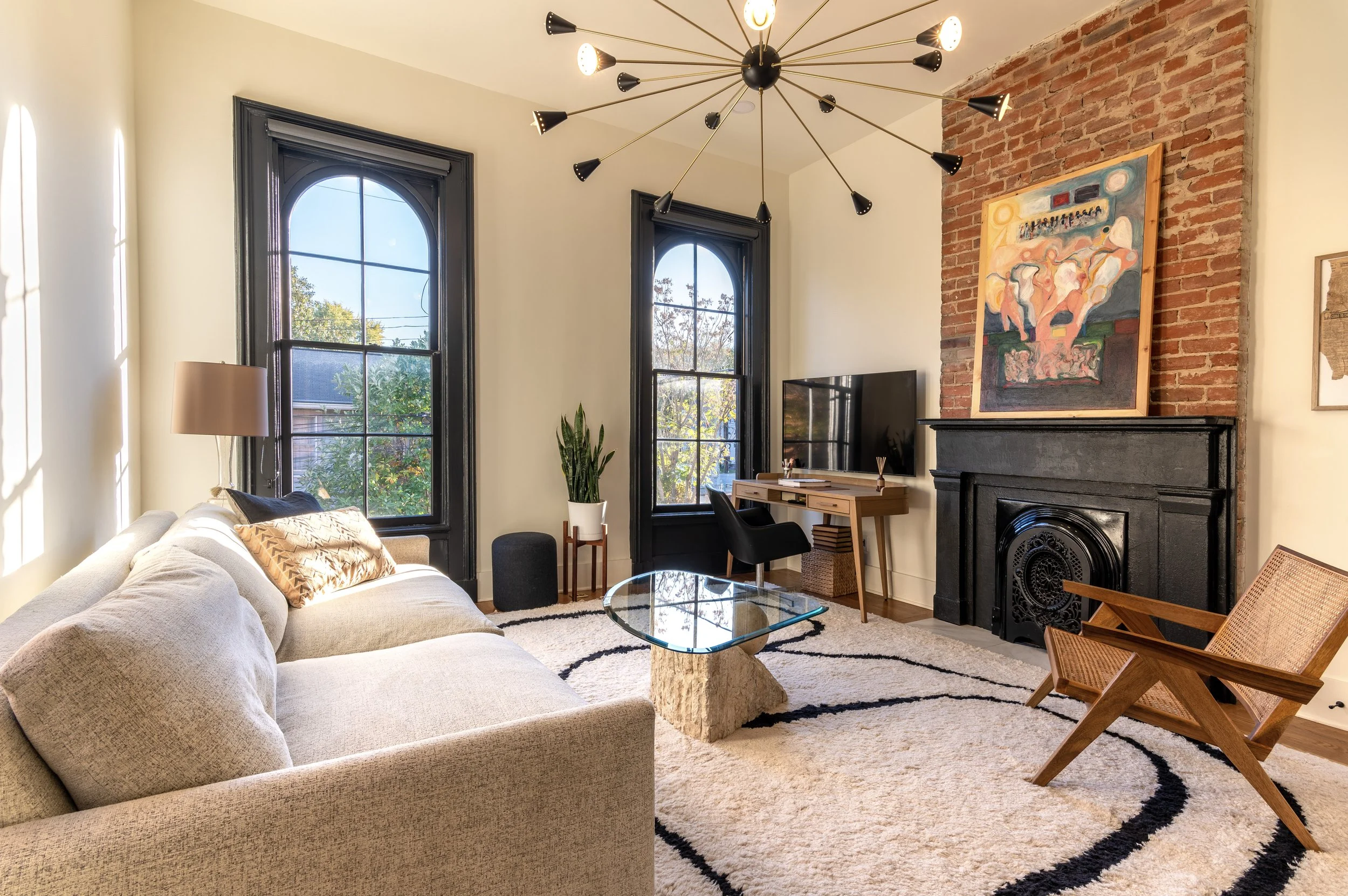Remodeled living room with original arched windows and designer lighting in Covington Kentucky by Shade Tree Homes