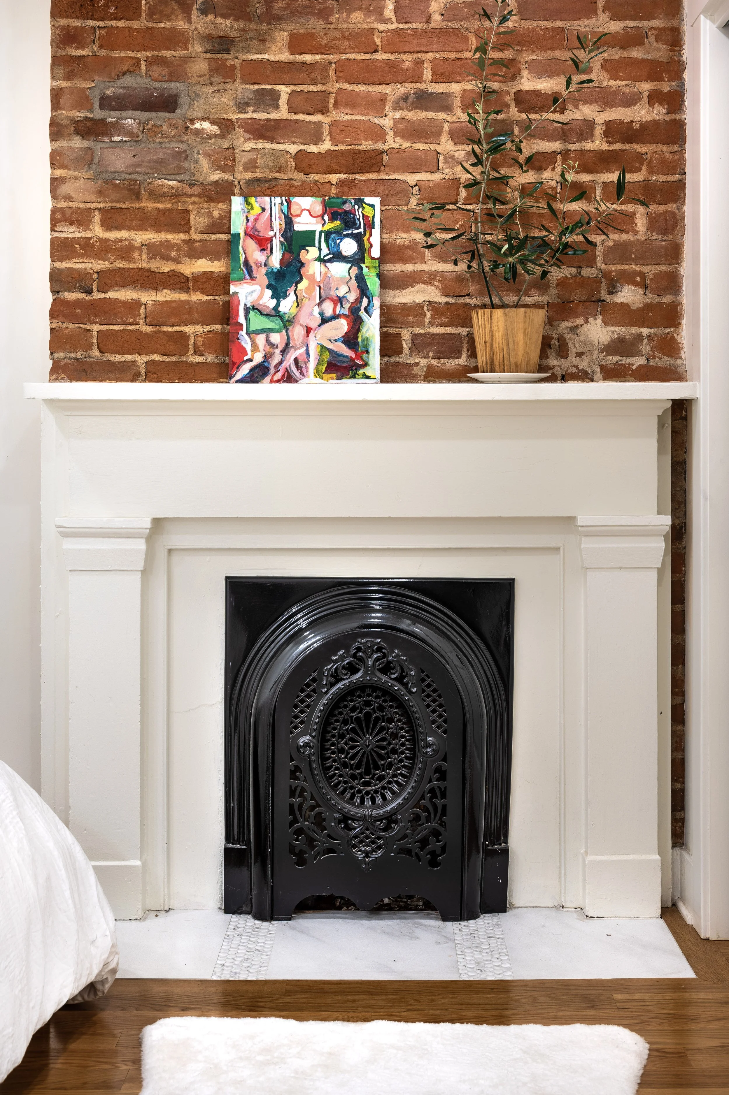 Restored original fireplace with ornate surround and exposed brick in Covington Kentucky by Shade Tree Homes