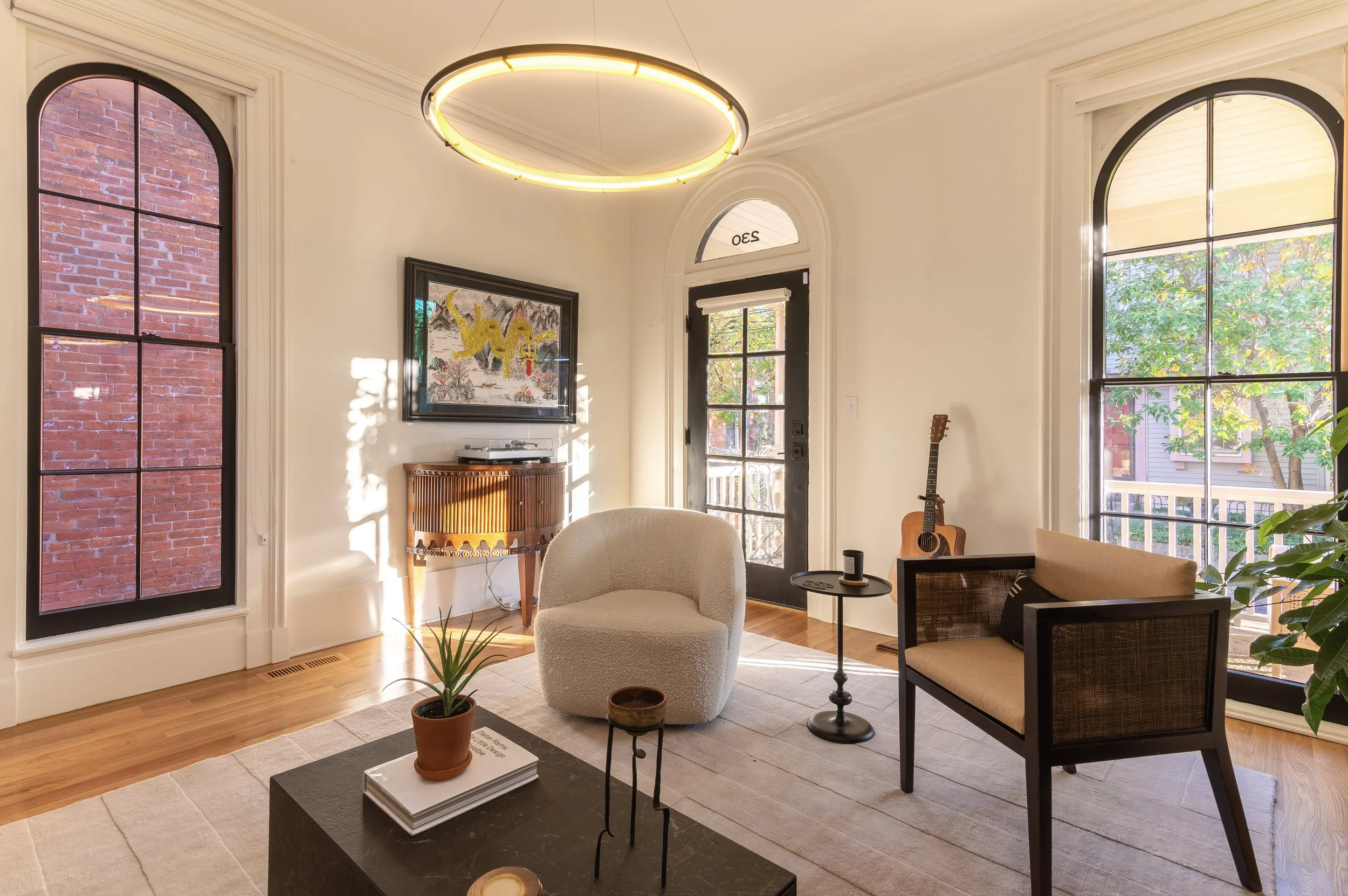 Historic Covington Kentucky home remodel living room with original fireplace and arched windows by Shade Tree Homes