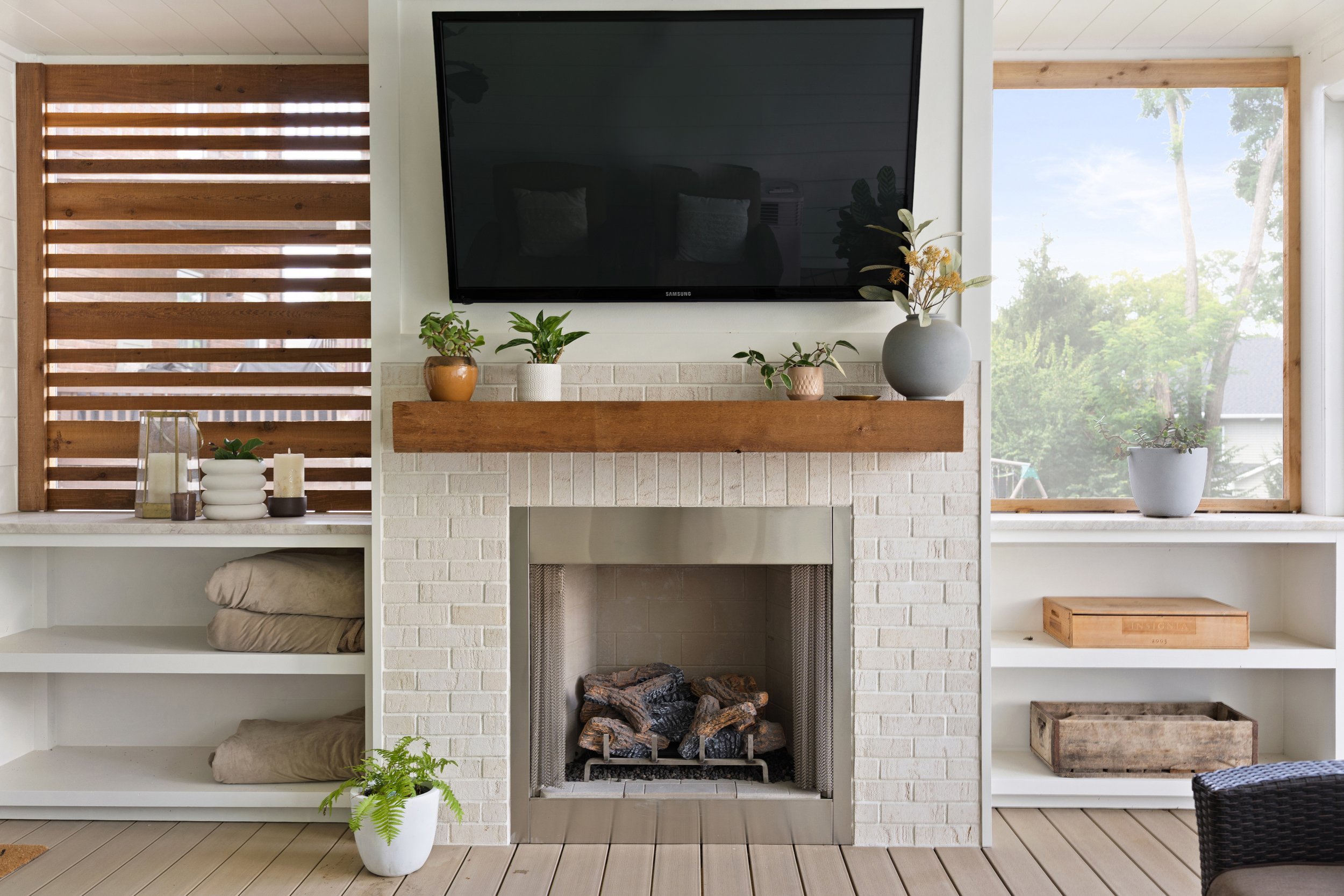 Custom outdoor living space with fireplace and covered ceiling by Shade Tree Homes