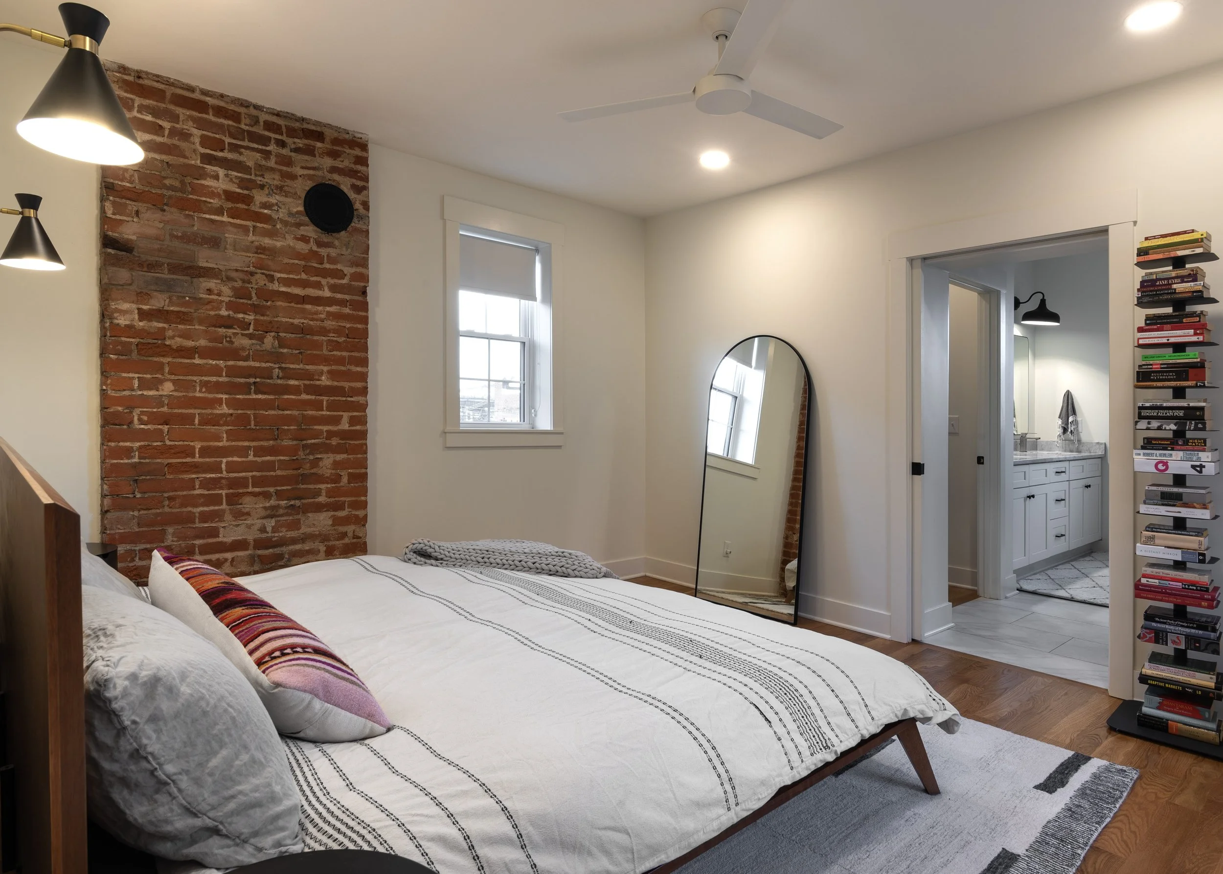 Primary bedroom with original brick and modern finishes in Covington Kentucky remodel by Shade Tree Homes