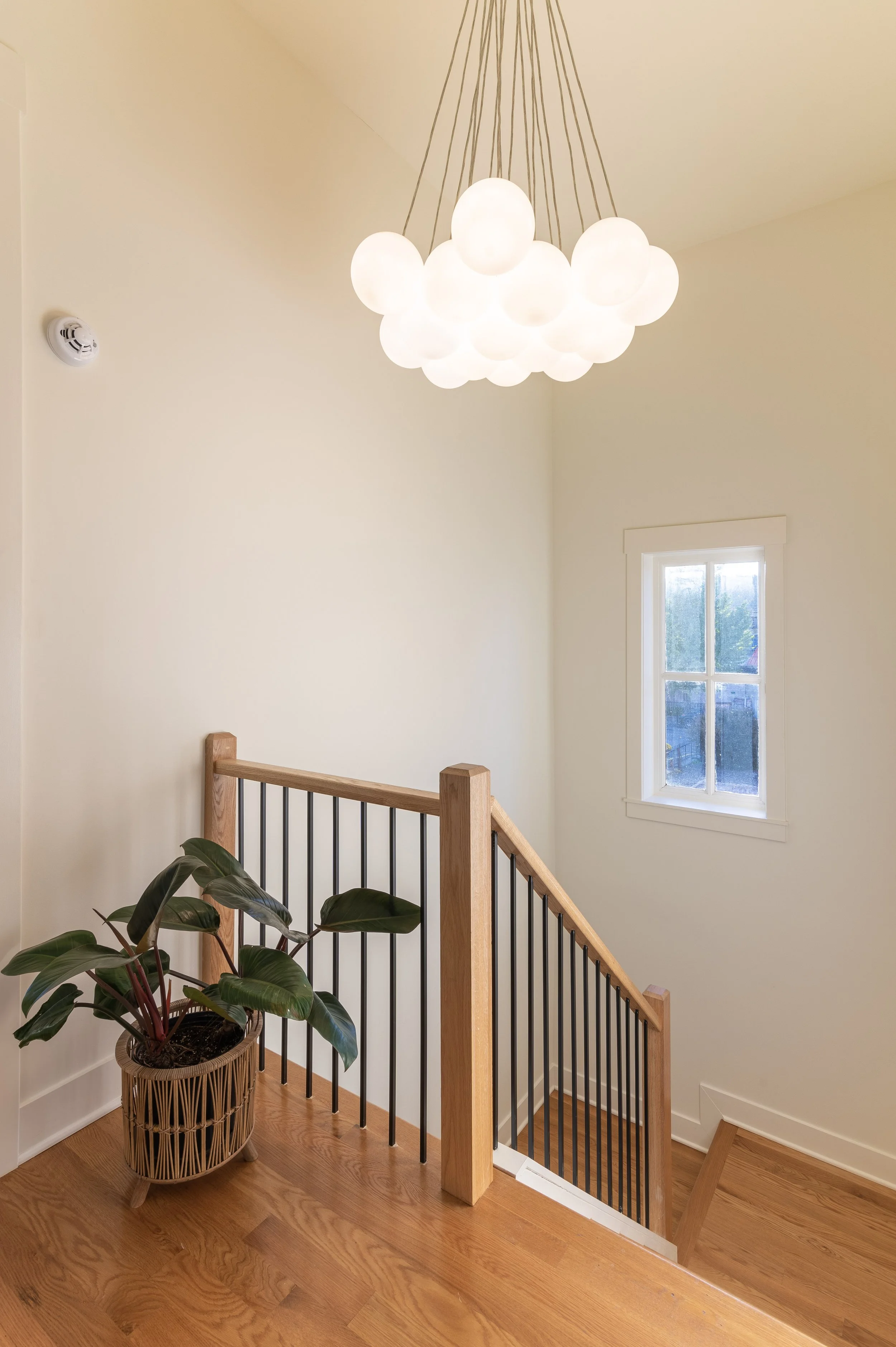 Upper landing with modern wood banister in historic Covington Kentucky remodel by Shade Tree Homes