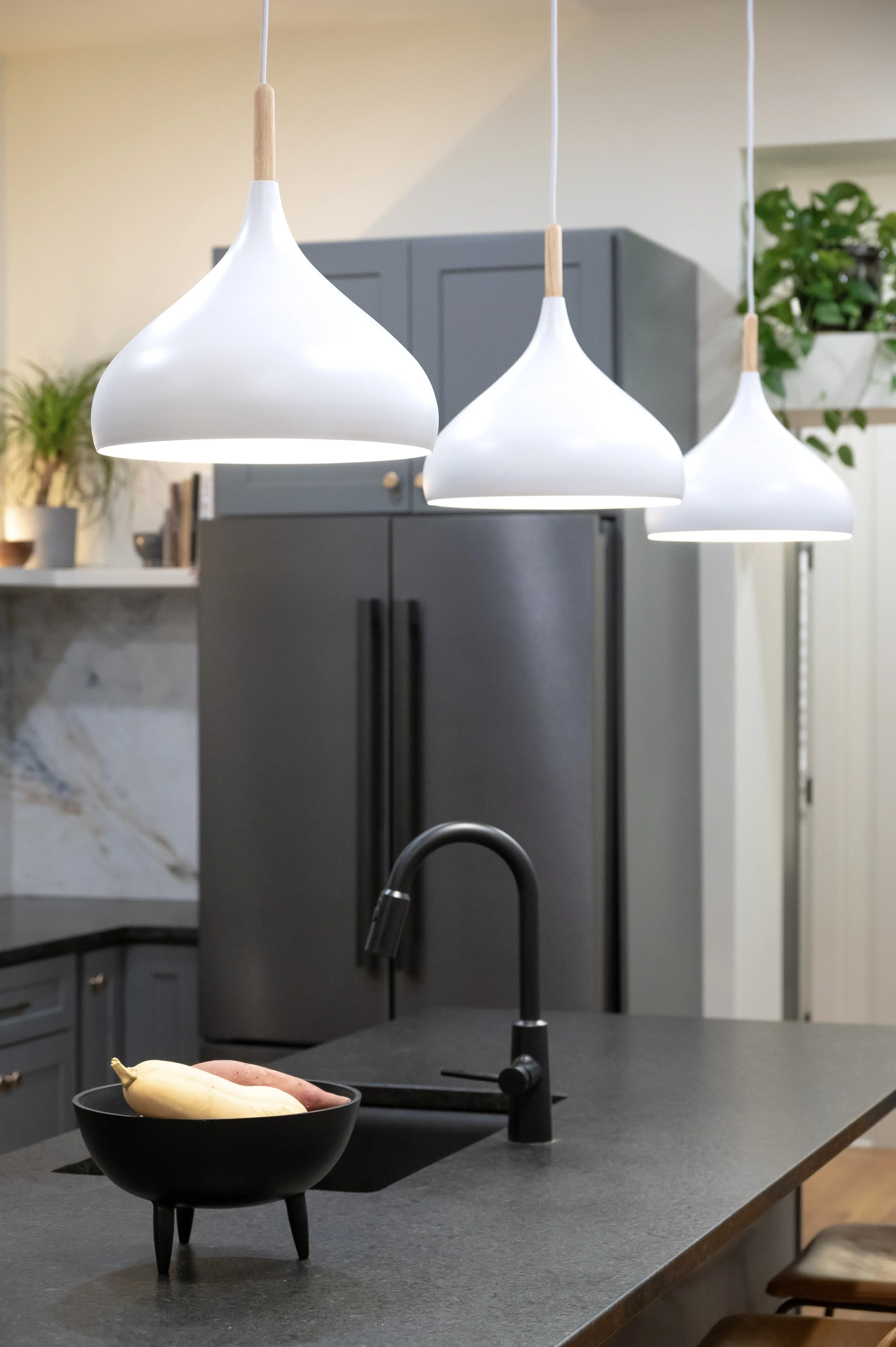 Designer pendant lighting and integrated refrigerator in Covington Kentucky kitchen remodel by Shade Tree Homes