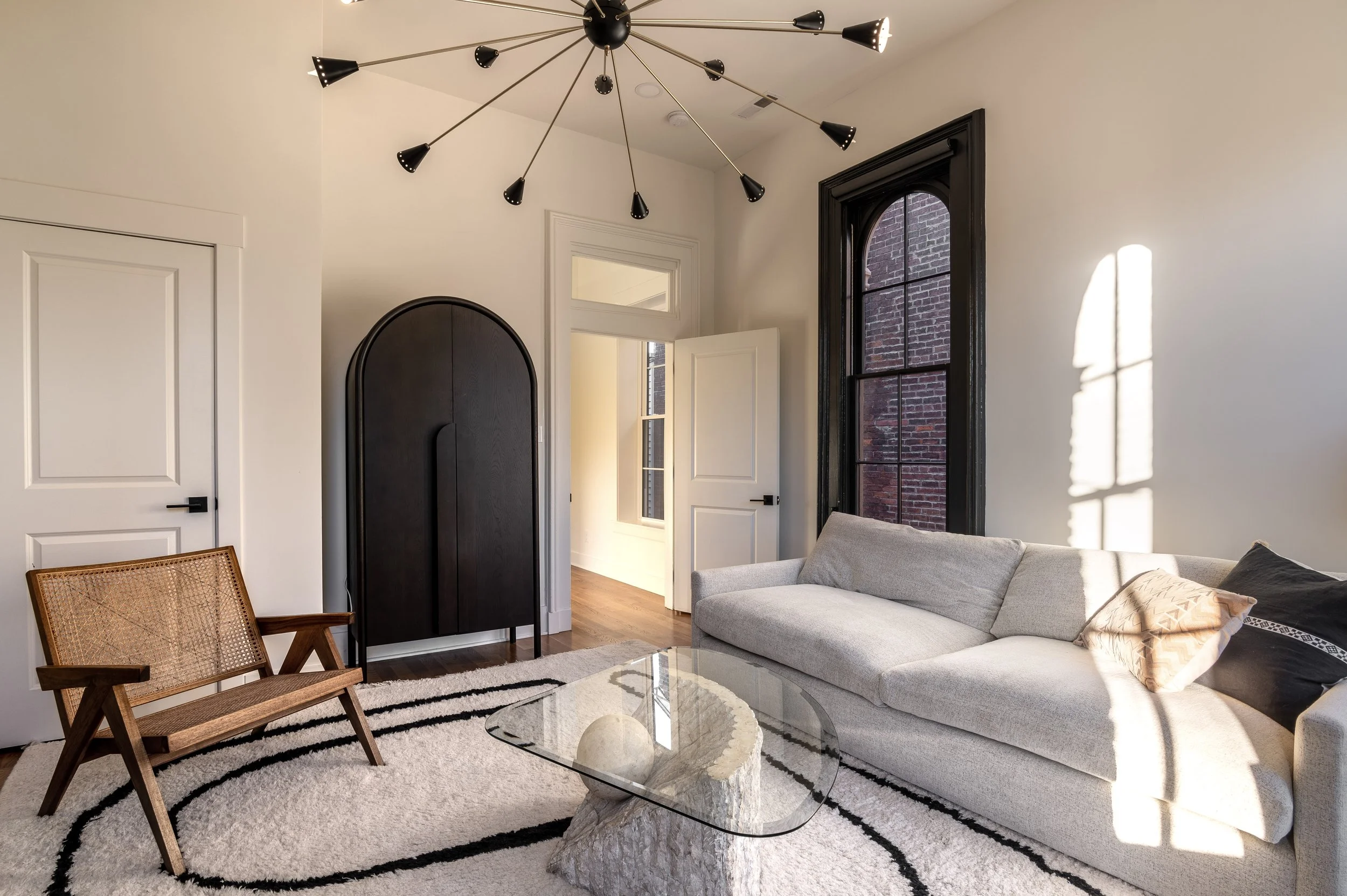 Historic Covington Kentucky living room with statement chandelier and original architectural details by Shade Tree Homes