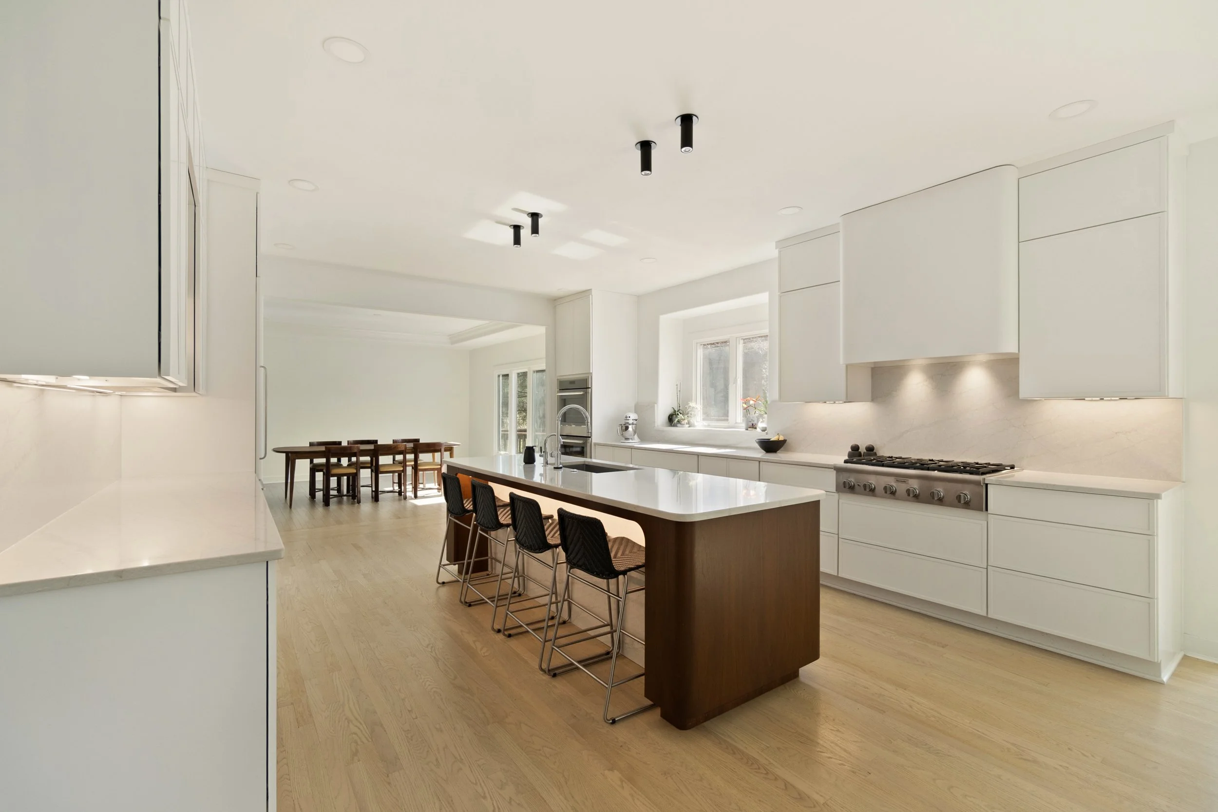 Custom kitchen overview showing layout, lighting, custom walnut island and cabinetry in Amberley Village home by Shade Tree Homes