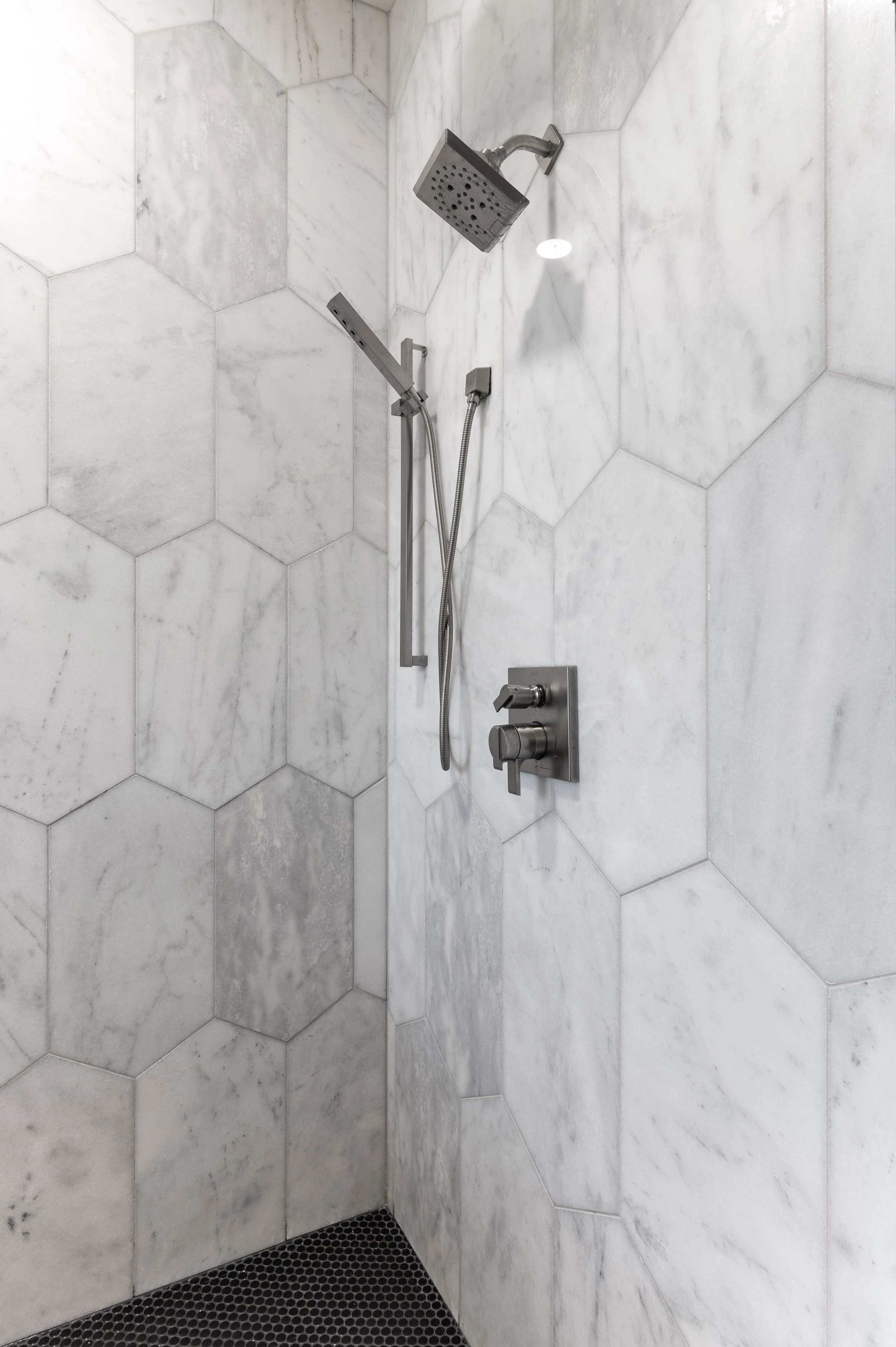 Large format marble tile shower in primary bath Covington Kentucky historic remodel by Shade Tree Homes