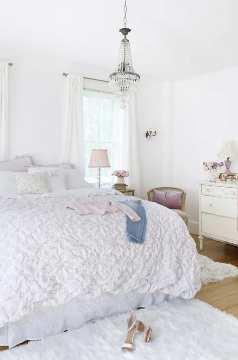  The home of Jo-Anne Coletti with a white fireplace mantel decorated with pink and white flowers in vases and a painting of pink roses.