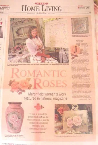 Front page of a newspaper featuring a woman with roses and pottery, with the headline 'Romantic Roses' and a smaller headline about a Marshfield woman's work.