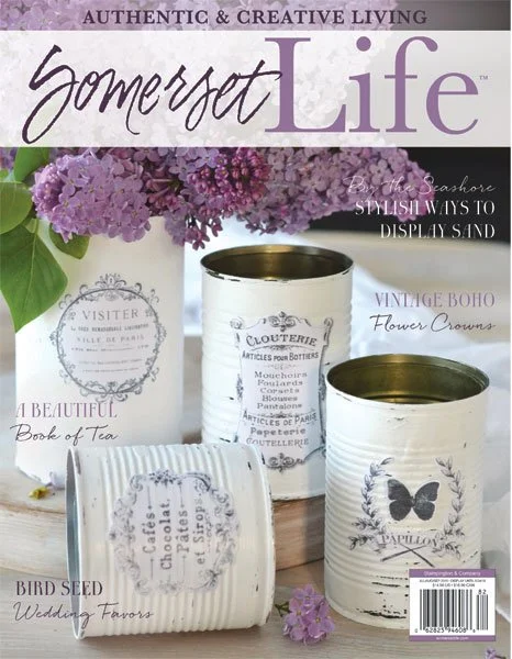 Cover of Somerset Life magazine featuring repurposed vintage cans with floral and butterfly decorations, purple flowers in background, and various decorative text.