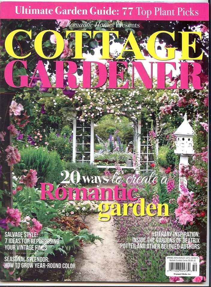 Cover of Cottage Gardener magazine with a garden scene featuring flowering plants, a white birdhouse, and a garden archway covered with pink and purple flowers.