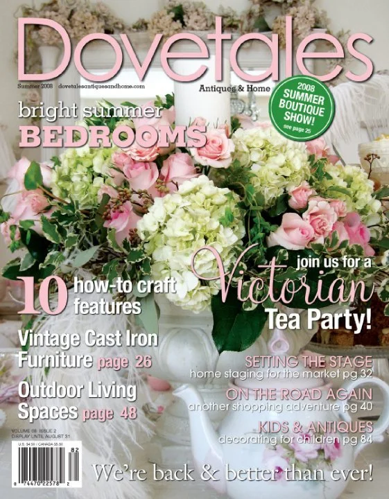 Magazine cover titled "Dovetales" featuring a large bouquet of pink and white flowers in a white vase, with pink and green text promoting summer bedroom decor, Victorian tea party, vintage cast iron furniture, outdoor living spaces, kids and antiques