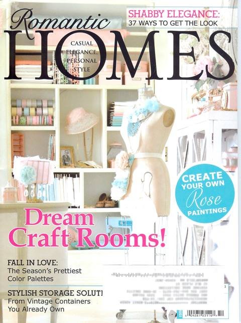 Jo-Anne Coletti Cover of a magazine titled "Romantic Homes" featuring a craft room with shelves filled with colorful supplies, a mannequin draped with fabric, and a backdrop of craft materials, emphasizing stylish and personal decorating ideas.
