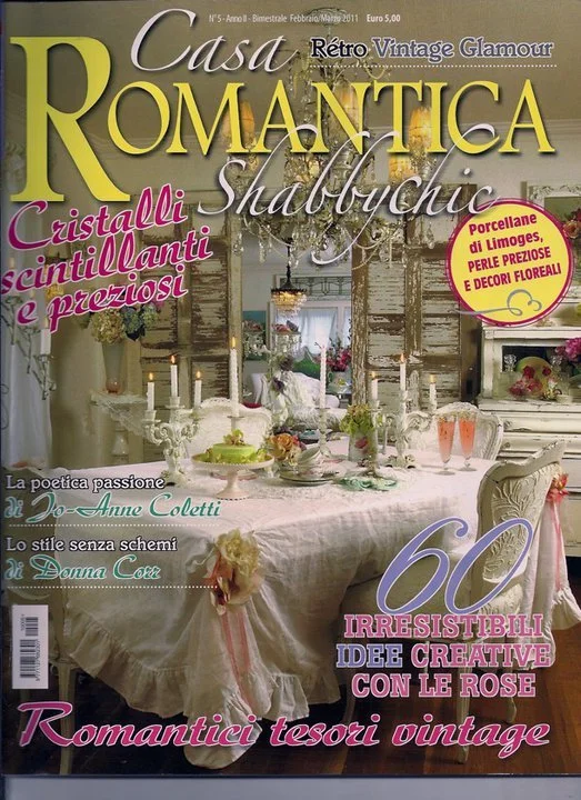 Cover of a vintage romantic home decor magazine featuring a decorated dining table with white and pink accents, candles, and floral arrangements. The magazine title is 'Casa Romantica' with various Italian text highlighting vintage glamour, crystal d