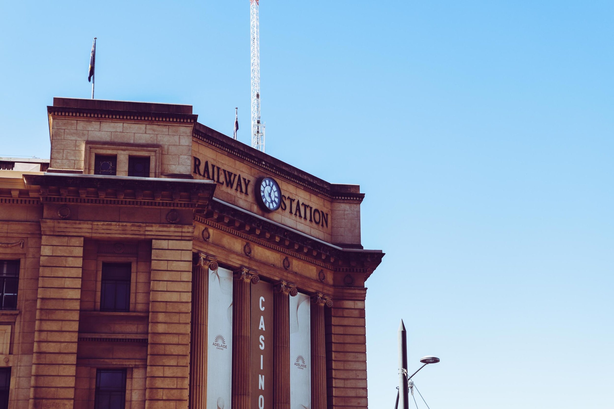 A tall building featuring a prominent clock on its rooftop against a clear blue sky.