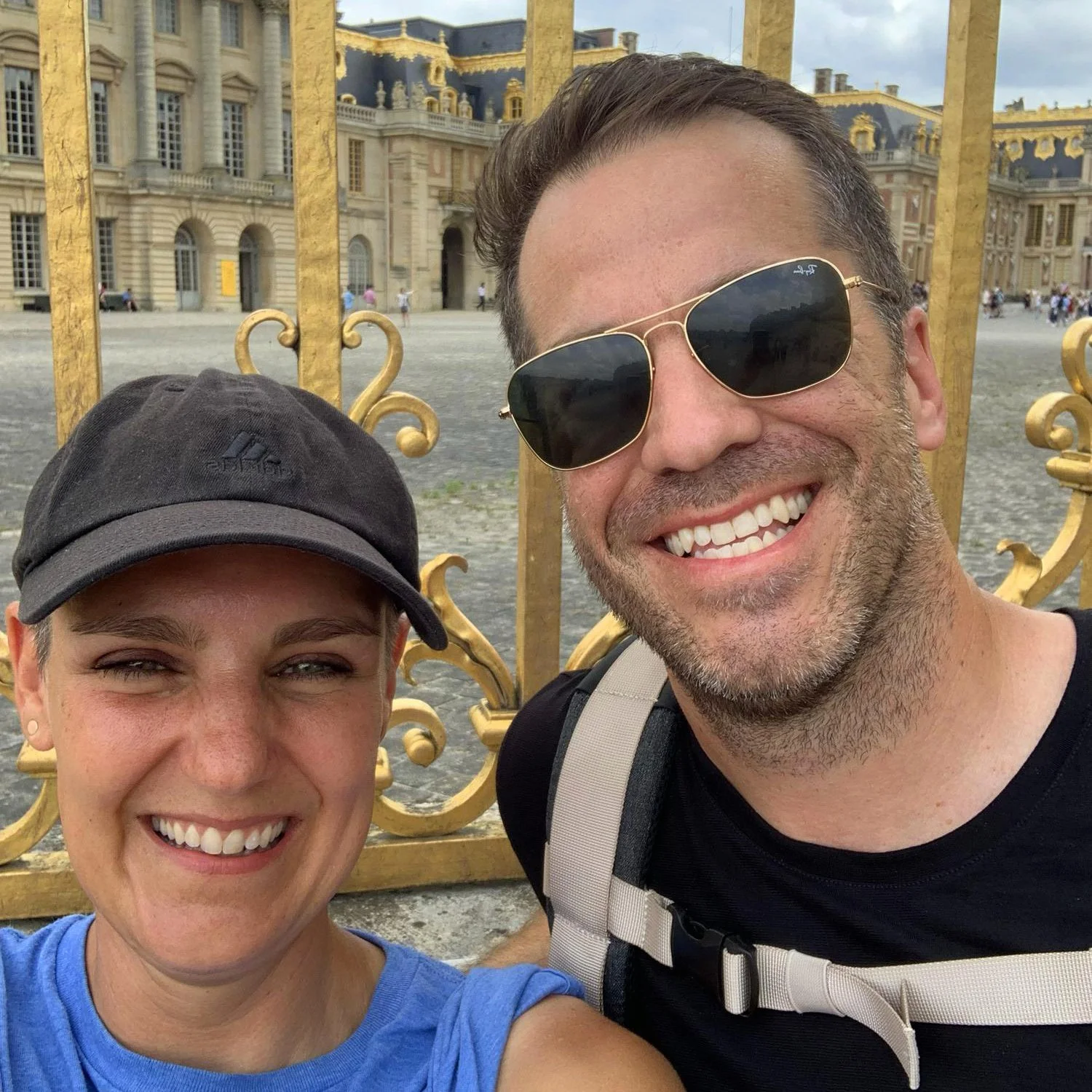 Friends taking a selfie in front of an the golden gates in front of the palace of Versailles