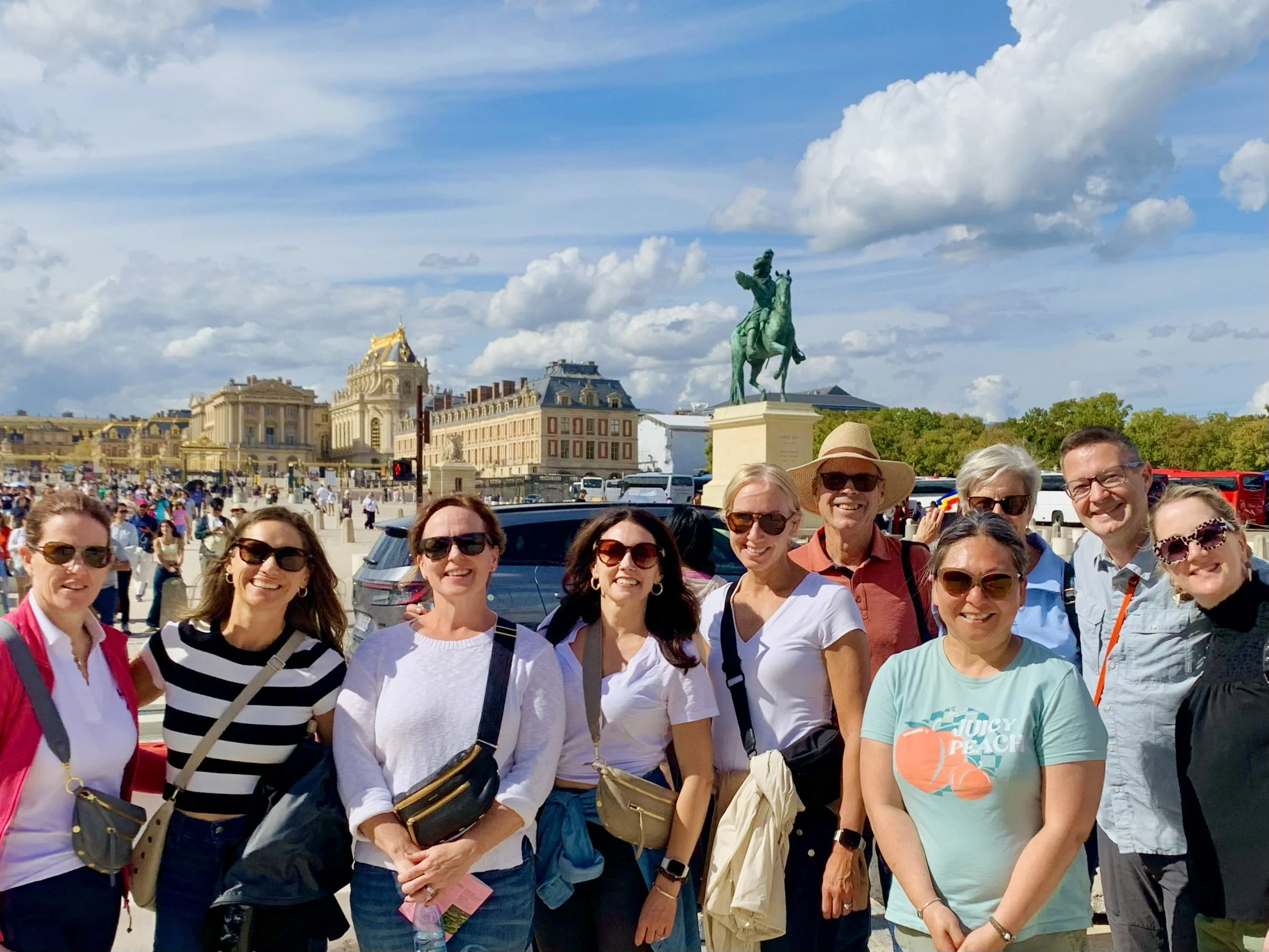 Uutdoors in front of the palace of Versailles and a statue of Louis XIV