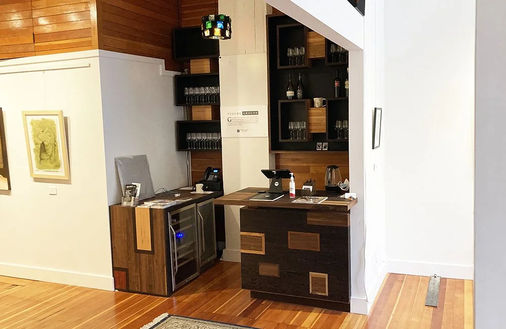 Beautiful custom woodwork defines this wine bar installed in a gallery space.