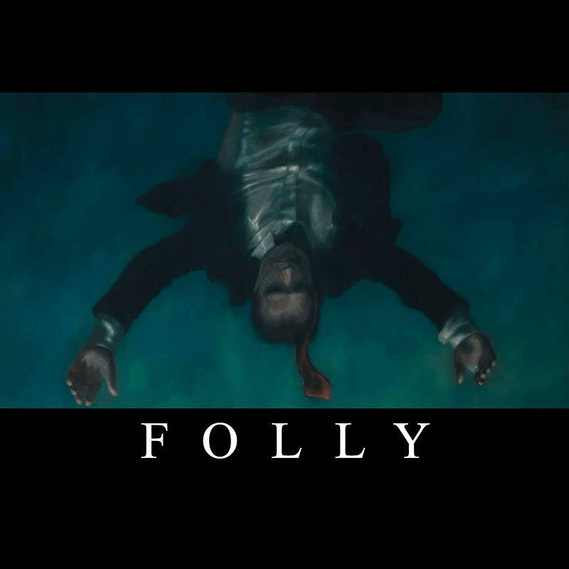 A person floating upside down in water, with long hair and a beard, wearing dark clothing. The word "FOLLY" is written at the bottom in white capital letters against a black background.