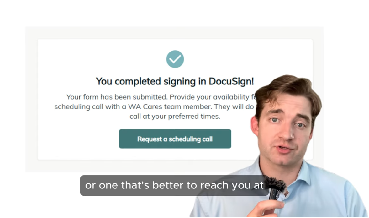 A man in a blue shirt holding a microphone speaking in front of a computer screen with a completion message from DocuSign. The message confirms signing in and provides an option to request a scheduling call.
