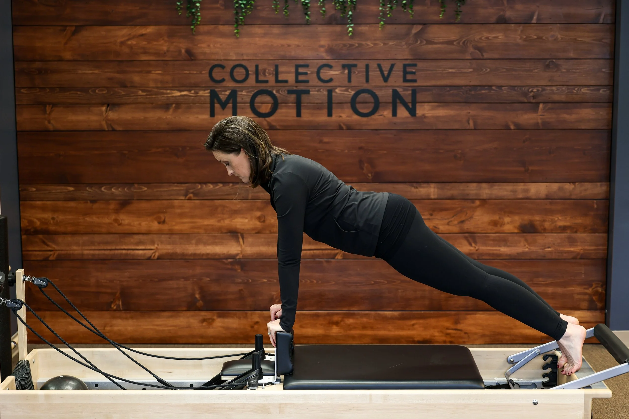 Elsa Gould performing Pilates exercises on reformer machine in her physical therapy and Pilates studio in Evanston IL