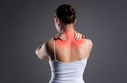 woman grabbing her upper back and neck in pain