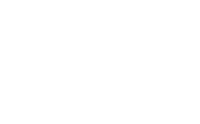 A three-tiered chocolate cake with chocolate frosting and a topping of fruit and edible decorations.