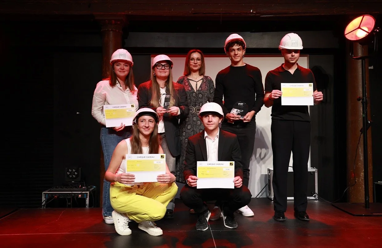 Groupe de jeunes portant des casques de chantier recevant des prix lors d'une cérémonie.