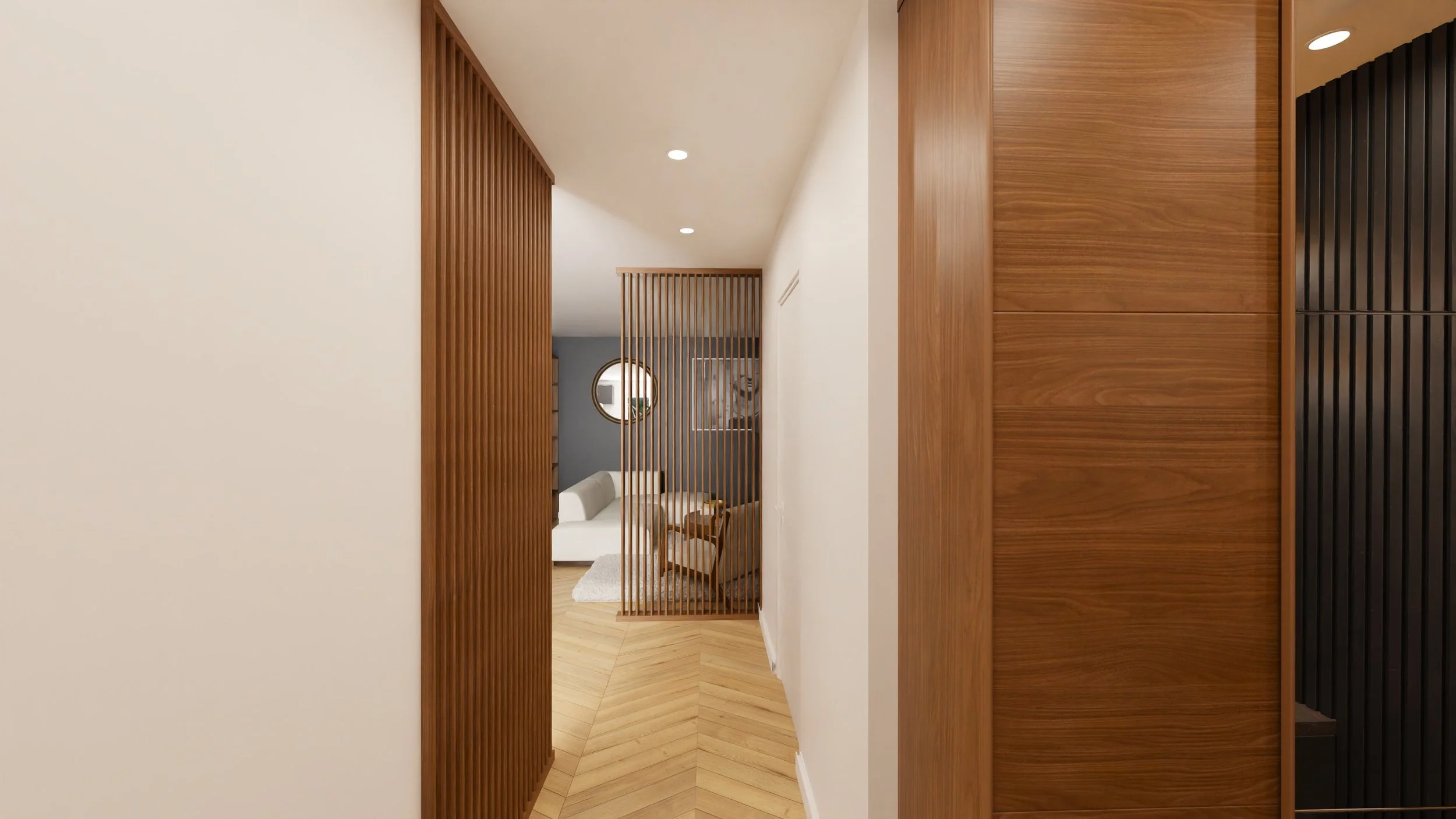 Rénovation haut de gamme d'un appartement avec vue depuis un couloir intérieur vers un salon, avec des éléments en bois tels que des panneaux, un parquet en motifs diagonaux, et un mur gris avec un miroir rond. Agencement sur mesures.