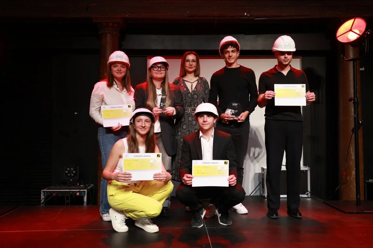 Groupe de jeunes portant des casques de chantier recevant des prix lors d'une cérémonie.