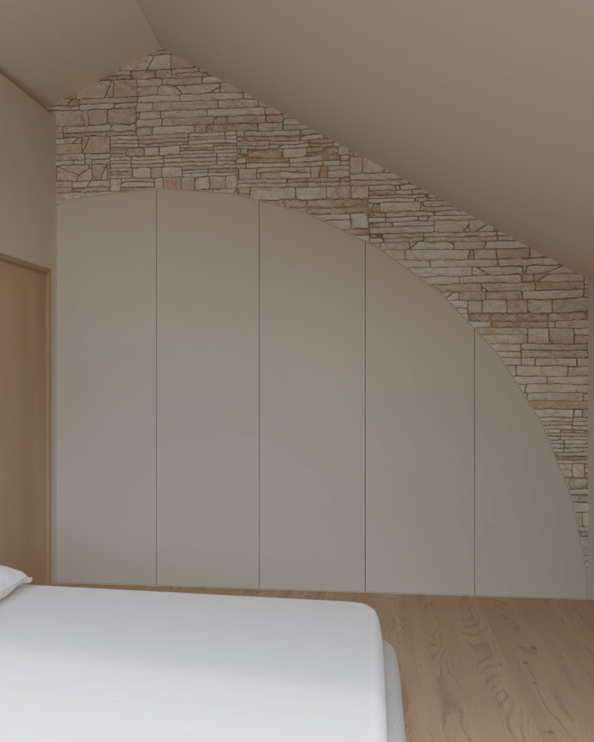 Rénovation haut de gamme d'une maison dans l'Aveyron, à Cantobre avec mur en pierre et dressing dans le mur dans une chambre avec un lit visible en bas à gauche. Agencement sur mesures.
