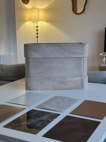 Maquette en bois de l'applique de la chambre 4* pour le concours Talents d'archi 2025 Ynov x Formica et des échantillons de matériaux de couleurs et textures variées Formica pour l'applique sur une table, dans un décor design.