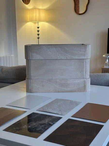 Échantillons de matériaux pour la décoration intérieure, avec différentes textures et couleurs, affichés sur une table.