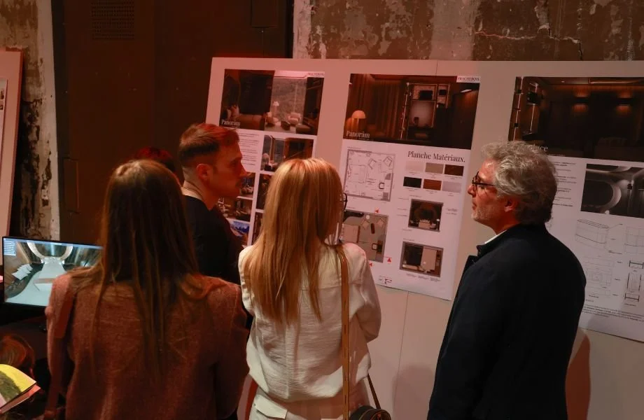Groupe de personnes regardant une affiche de présentation d'architecture ou de design intérieur dans une salle d'exposition ou une conférence.