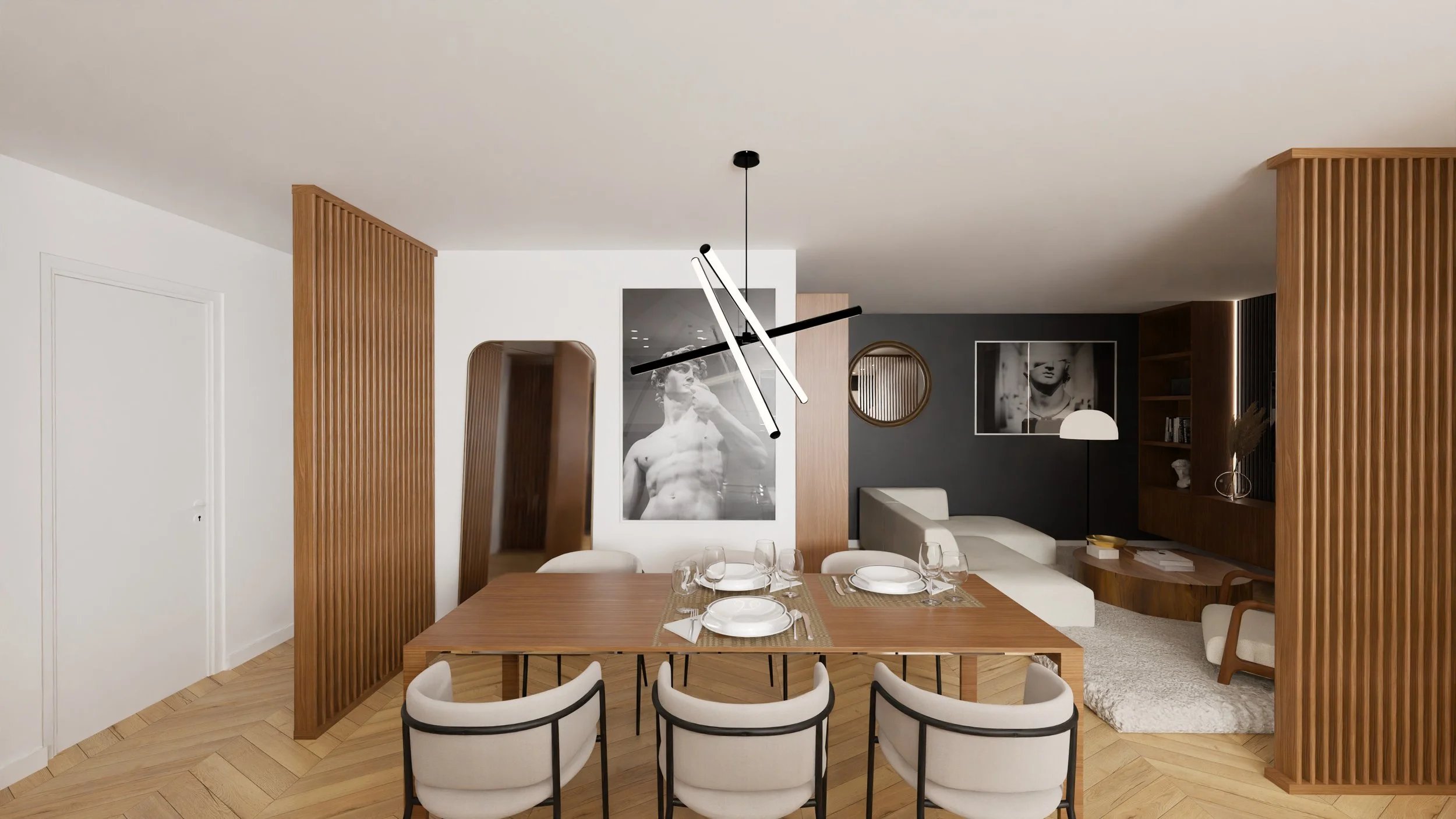 Intérieur moderne d'une salle à manger avec un grand tableau noir représentant une sculpture d'homme, une lampe suspendue au plafond, une table en bois, des chaises blanches et un coin salon avec un fauteuil. Agencement sur mesure.