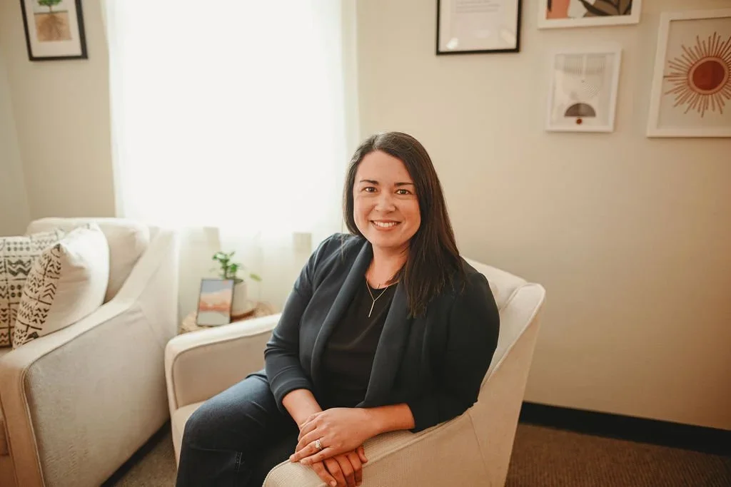 Christine, a modern trauma and couples therapist at Made Whole Counseling, smiling warmly in her comfortable office. She provides therapy intensives and counseling for clients in West Seattle, WA and Brentwood, TN.