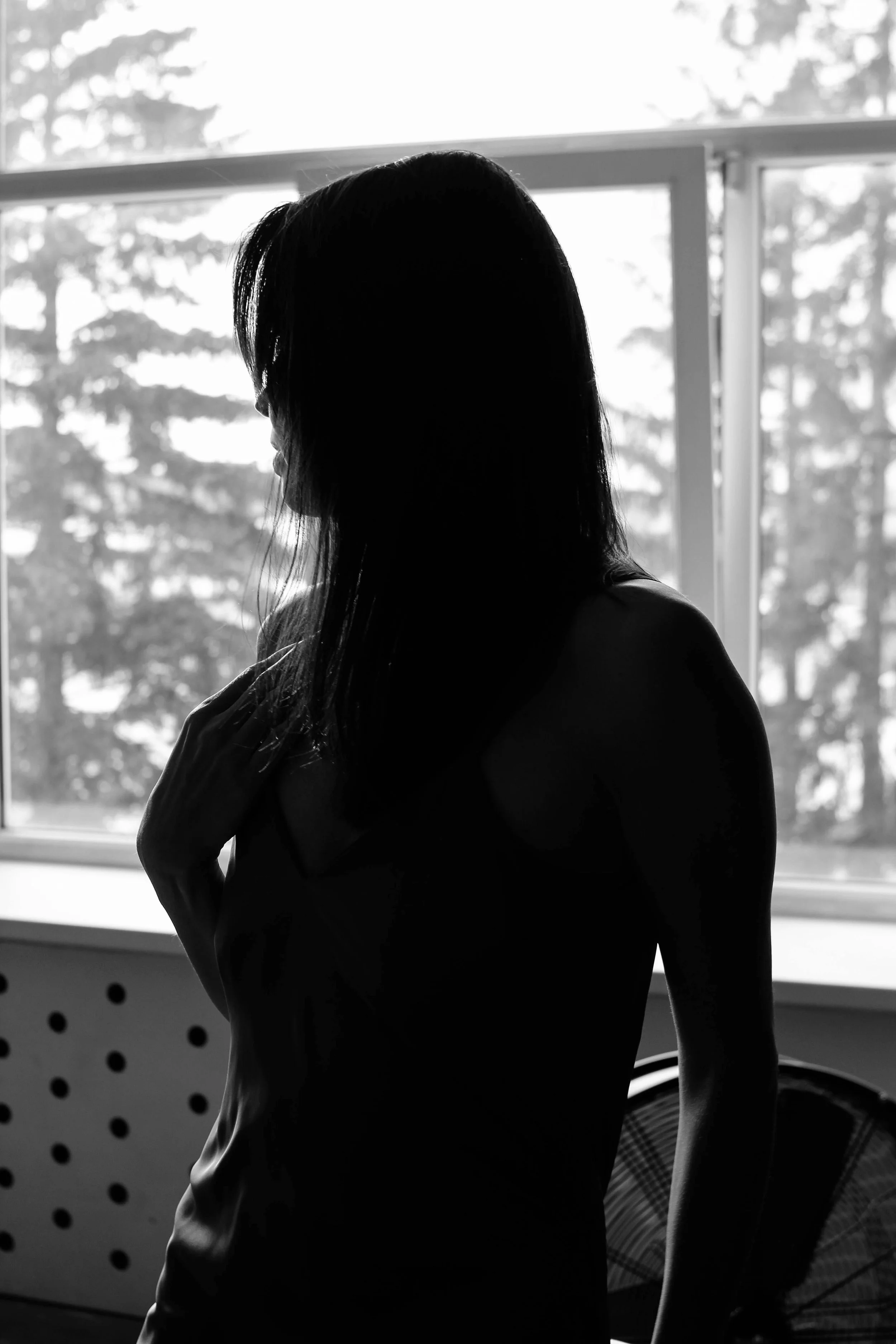 A woman looks calmly and reflectively off-camera toward natural light, representing the gentle, internal processing involved in Brainspotting therapy at Made Whole Counseling.