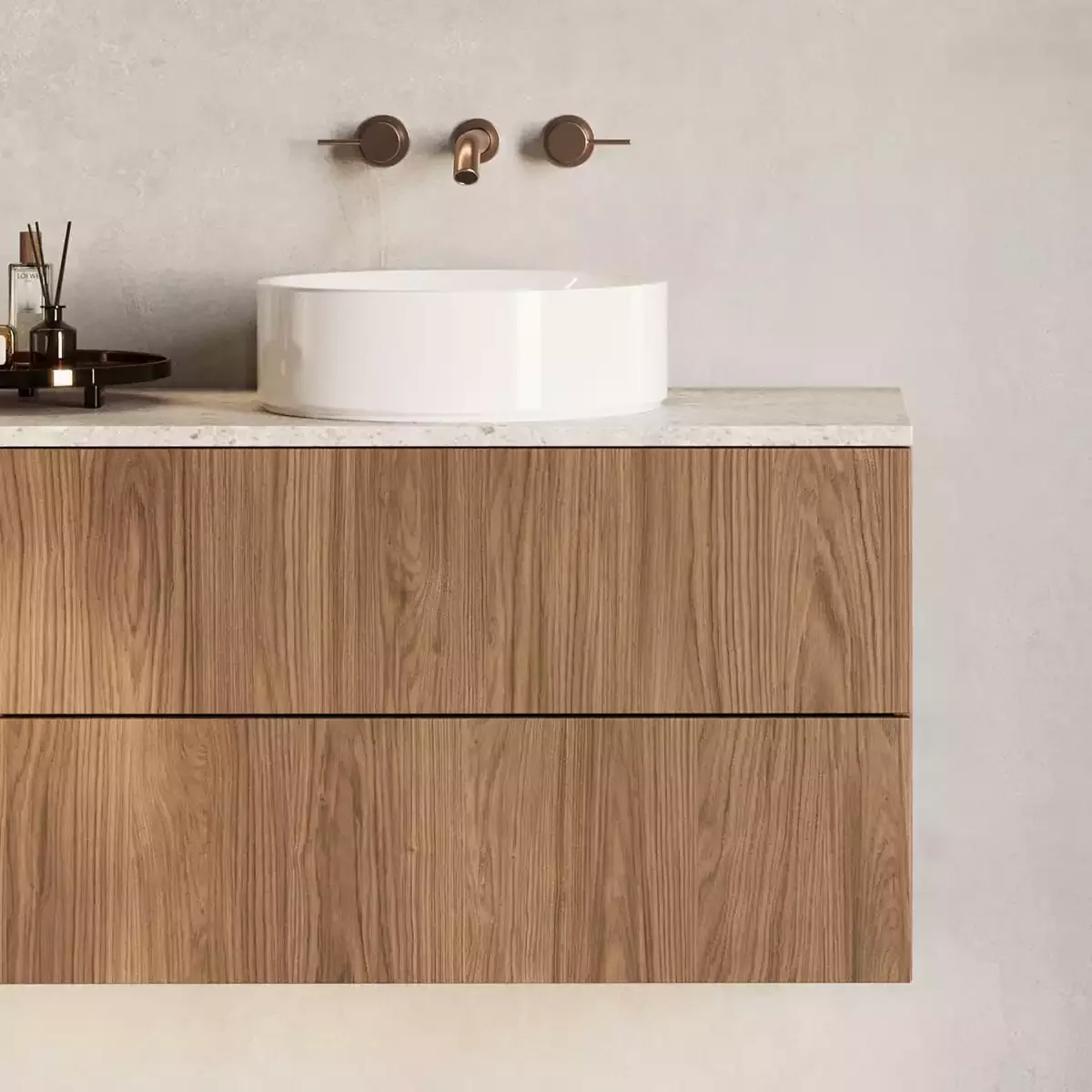 Modern bathroom vanity with a white vessel sink, brass faucet, and wooden cabinet, against a light-colored wall.