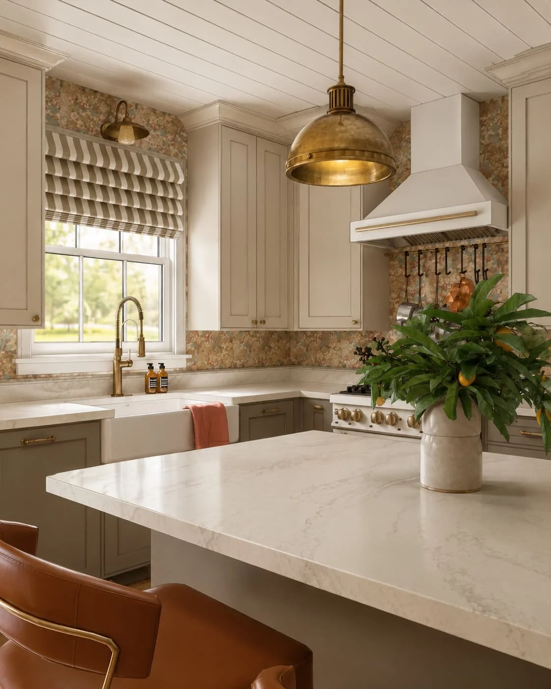 Kitchen with floral wallpaper, cream cabinetry, farmhouse sink, brass lighting, and warm neutral finishes.