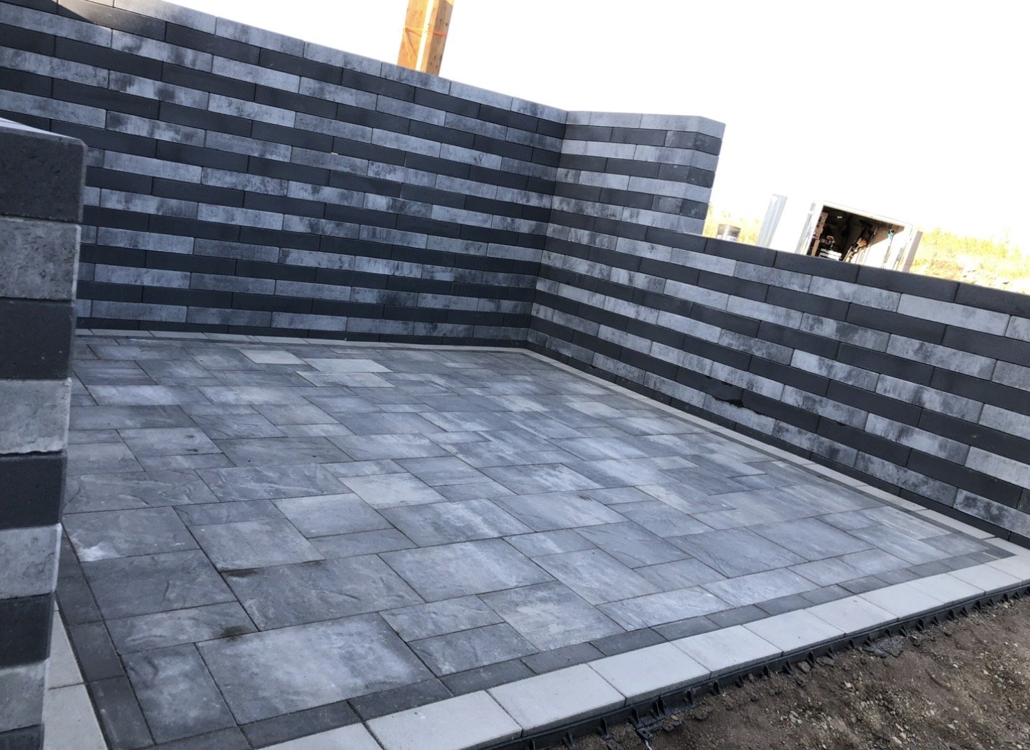 Construction site with stone brick wall and tiled floor, part of a building under construction.