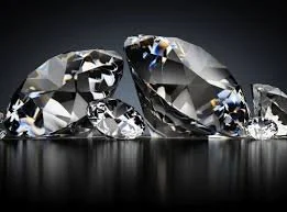 Close-up of several sparkling diamonds on a dark surface