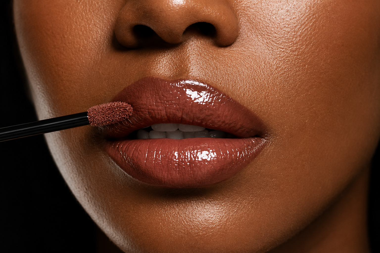 Close-up of a woman's lips with glossy lipstick, as she applies lip gloss with a wand.