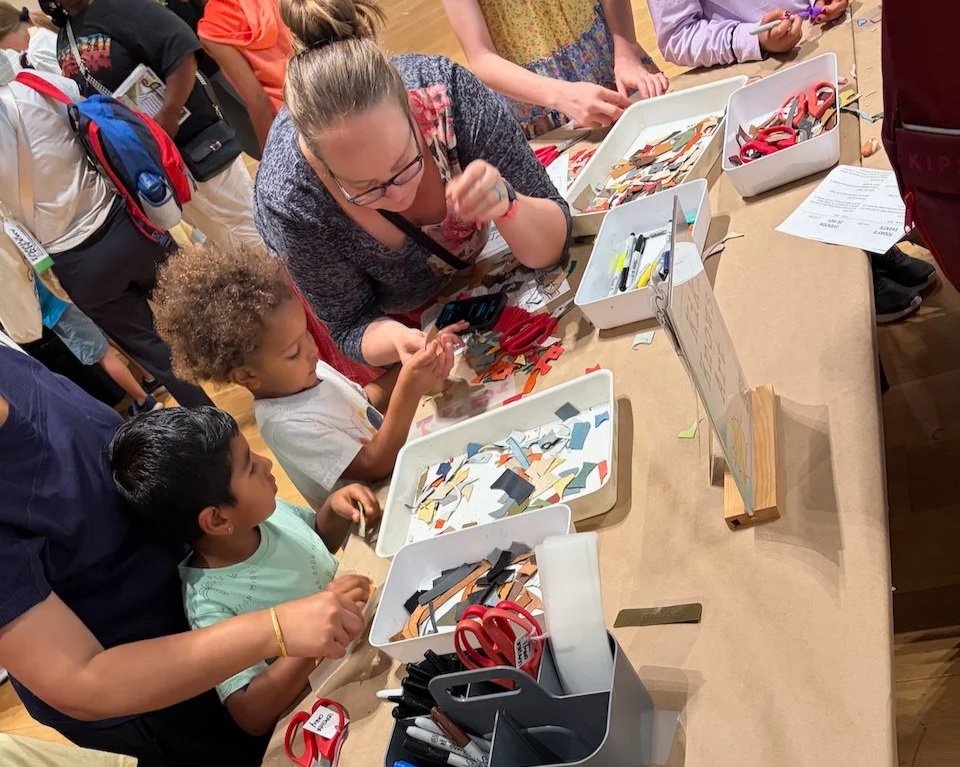 Children and woman choose their materials at a Kiki Knows Art workshop.