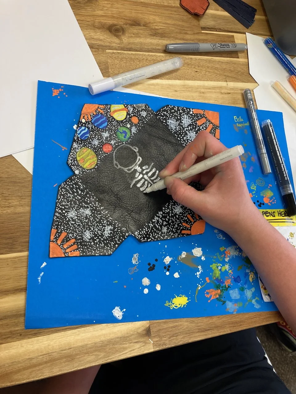 A hand drawing with paint pens on upcycled leather at a Kiki Knows Art workshop.