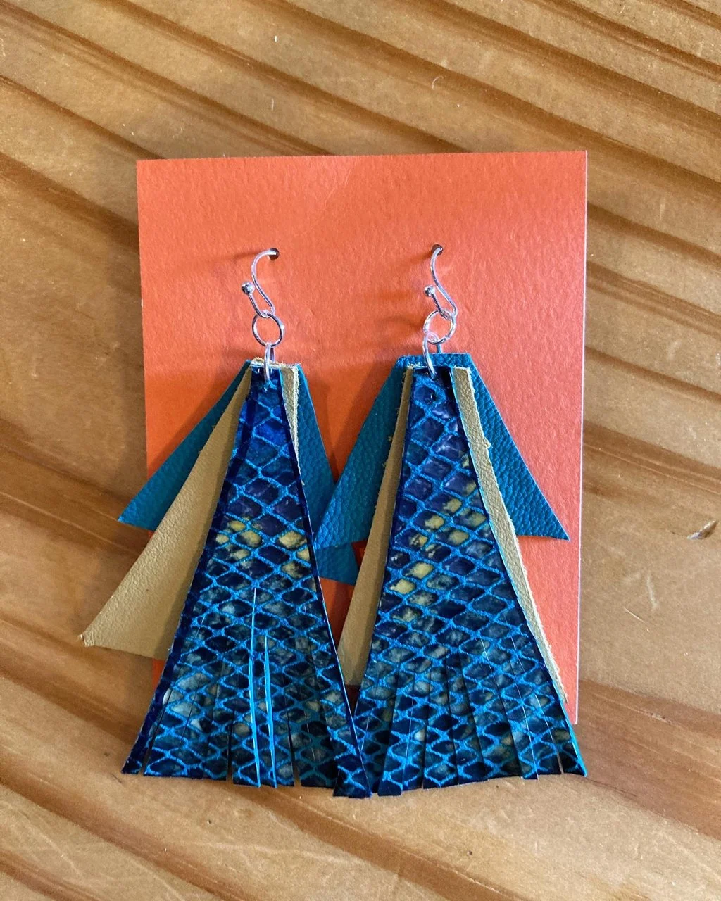Pair of bright blue earrings made from upcycled materials at a Kiki Knows Art jewelry workshop.
