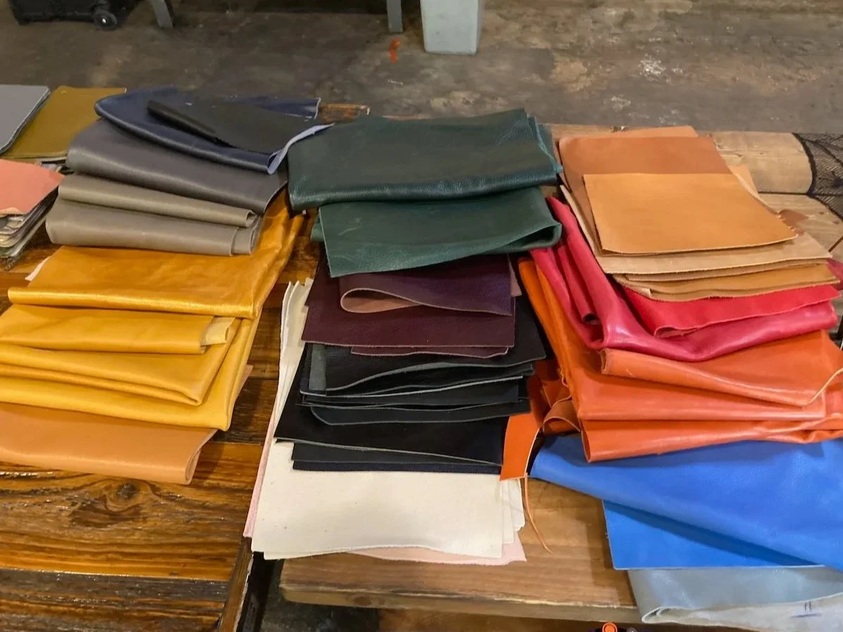 Stacks of colorful, upcycled leather to be used at a Kiki Knows Art workshop.