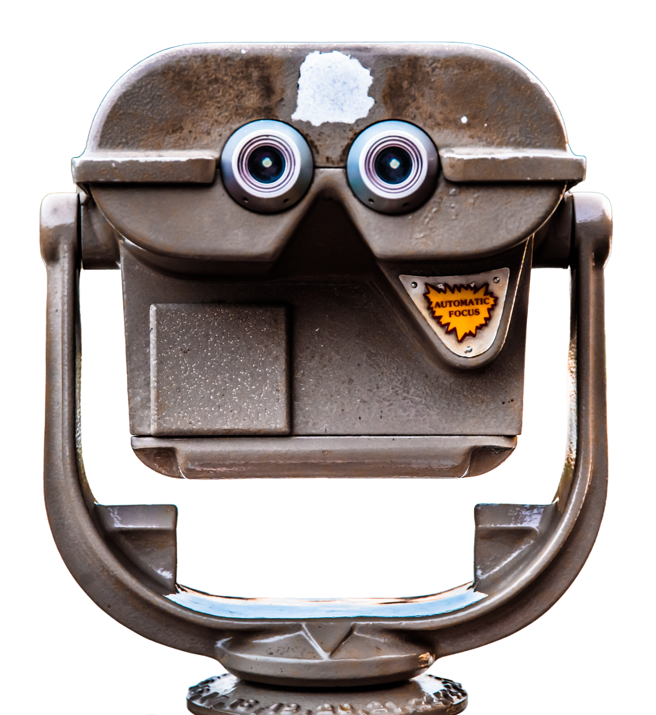 Close-up view of a vintage coin-operated binocular viewer with a face-like appearance, featuring large round lenses resembling eyes, a curved top resembling a forehead, and an orange sticker with the words 'Automatic Focus.'